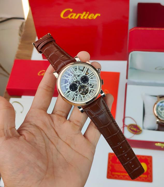 CARTIER A ROUND AUTOMATIC WATCH FOR MEN WITH A SKELETON DIAL AND BROWN LEATHER STRAP