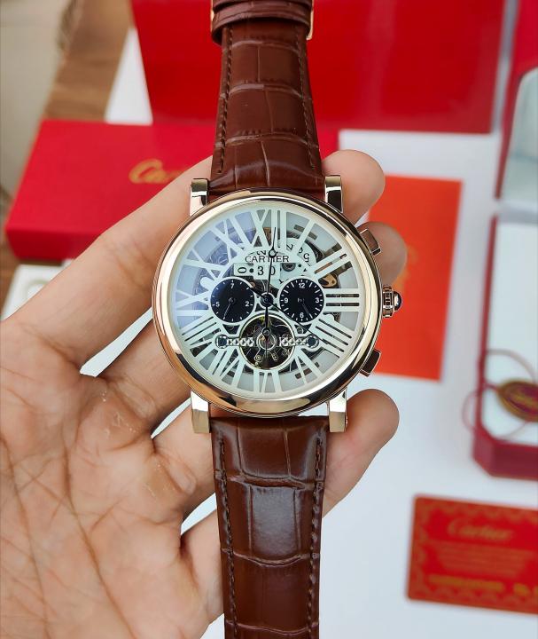 CARTIER A ROUND AUTOMATIC WATCH FOR MEN WITH A SKELETON DIAL AND BROWN LEATHER STRAP