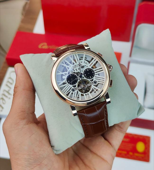 CARTIER A ROUND AUTOMATIC WATCH FOR MEN WITH A SKELETON DIAL AND BROWN LEATHER STRAP